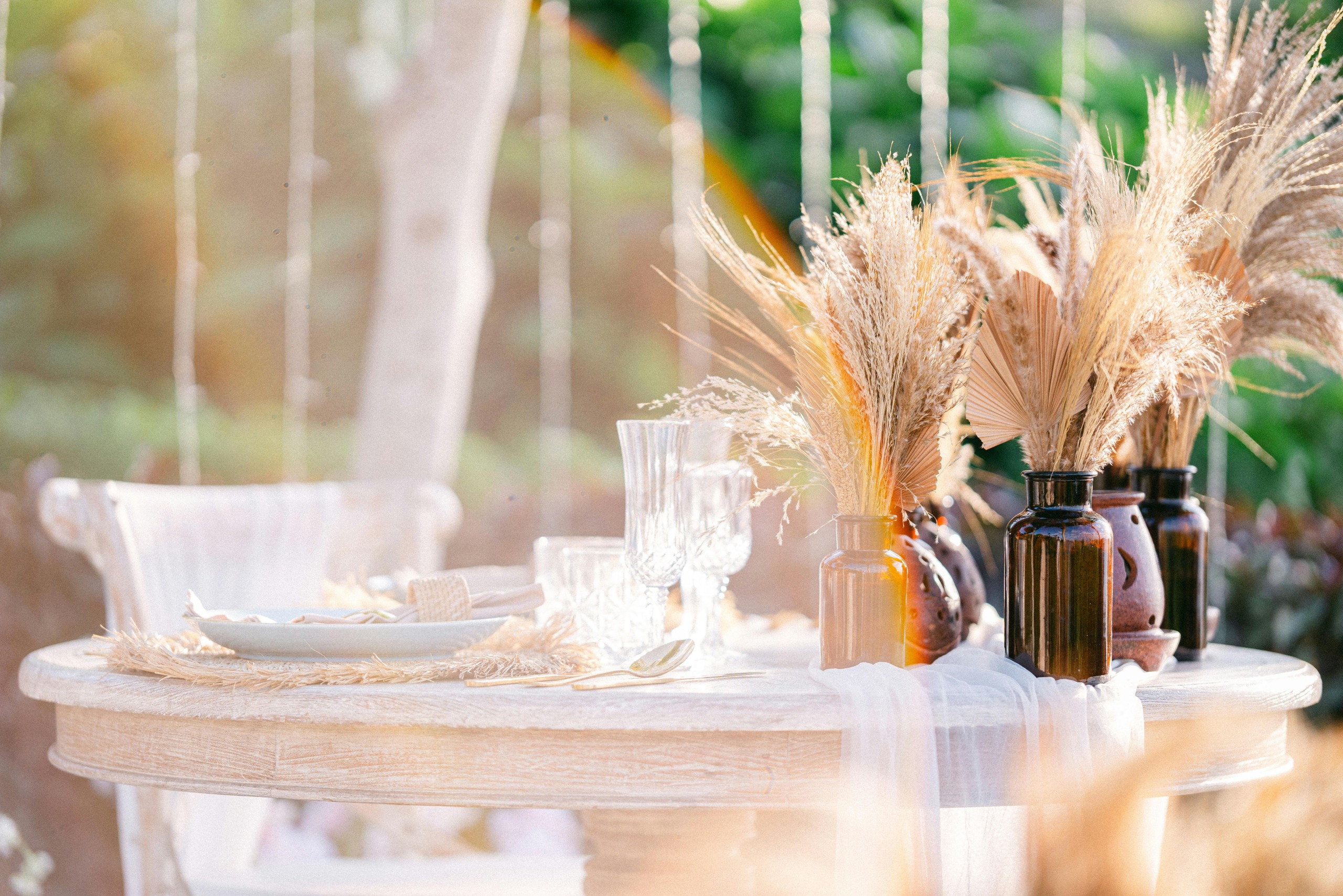 An elegantly set outdoor table with autumn-themed decor, perfect for a seasonal gathering.